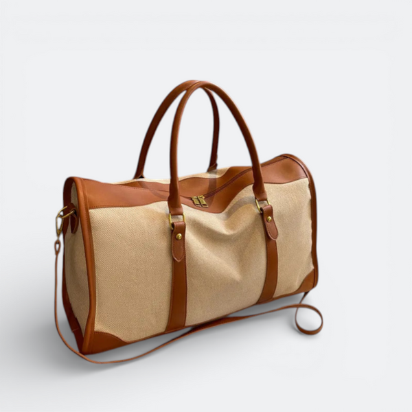 AïtaVia beige canvas and brown leather duffel bag with top handles and adjustable shoulder strap.