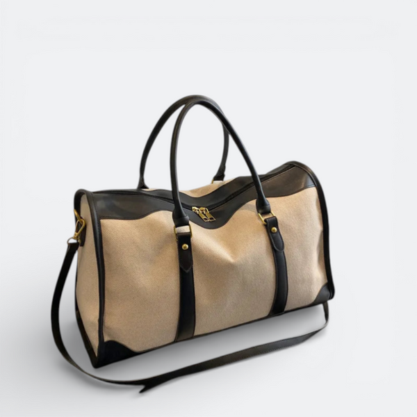 AïtaVia beige canvas and black leather duffel bag with top handles and shoulder strap.