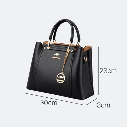 AïtaVia black pebbled leather tote handbag with gold kangaroo charm and chain detail. Top handles and structured shape.