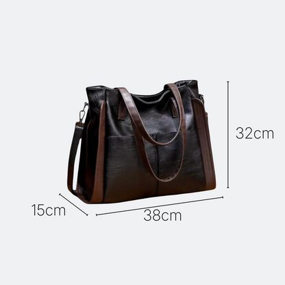 AïtaVia black soft leather tote bag with brown accents and shoulder strap. Features multiple pockets and a spacious interior.
