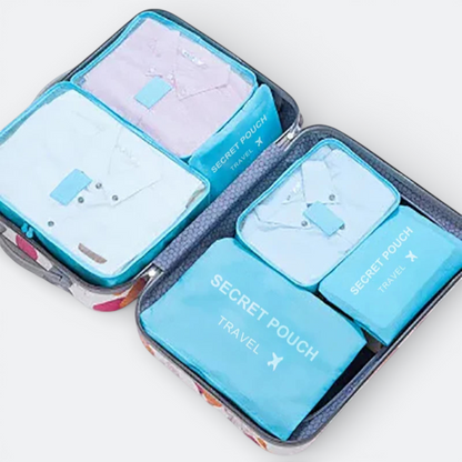 AïtaVia blue fabric packing cubes with shirts inside a suitcase for travel organization.