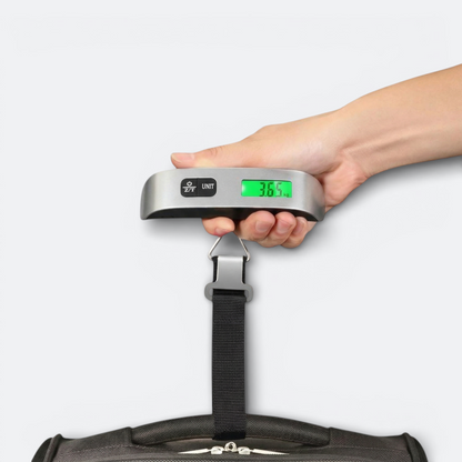 AïtaVia silver digital luggage scale with black strap weighing a suitcase, displaying 3.65 kg.