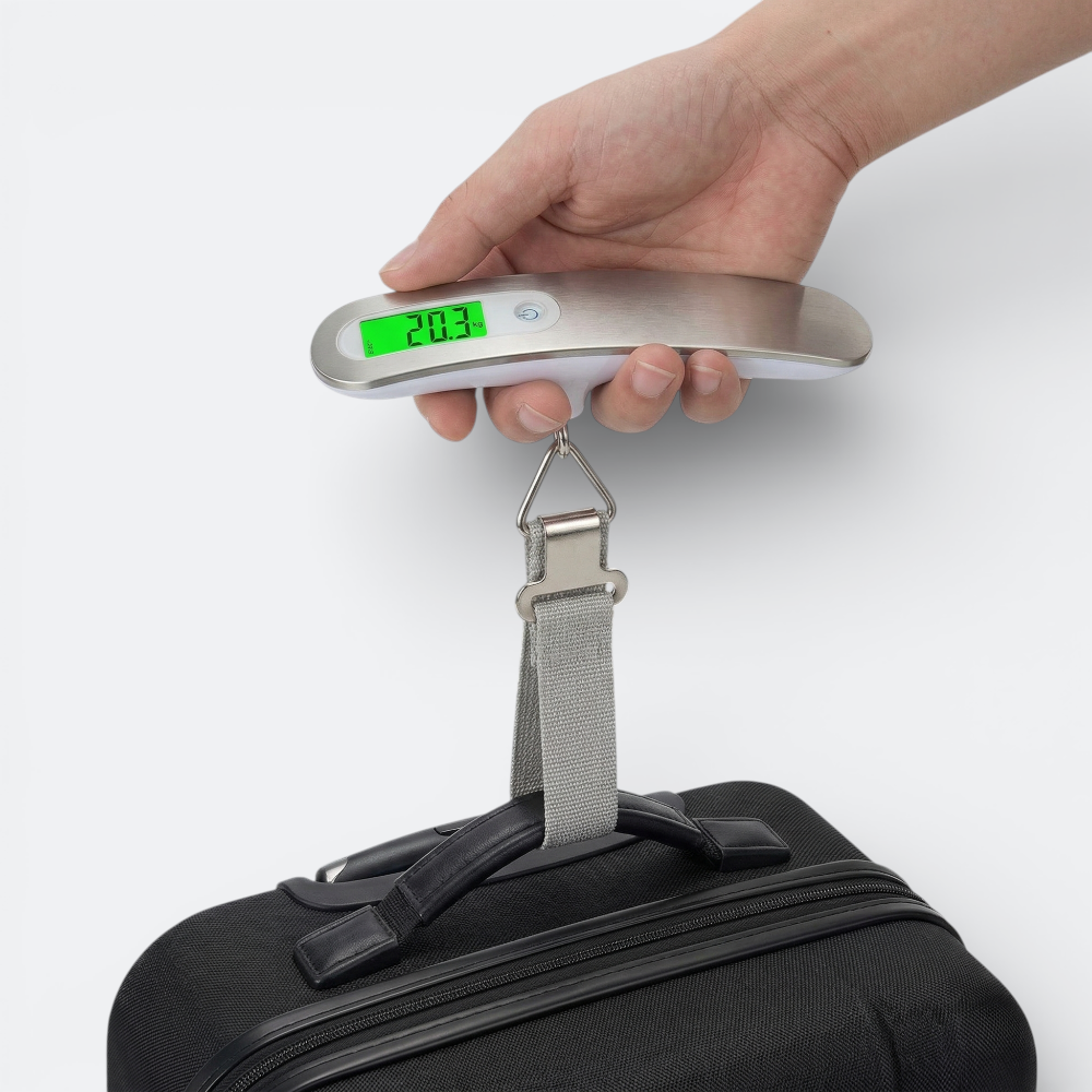 AïtaVia digital luggage scale in brushed metal with green LCD display weighing a black suitcase.