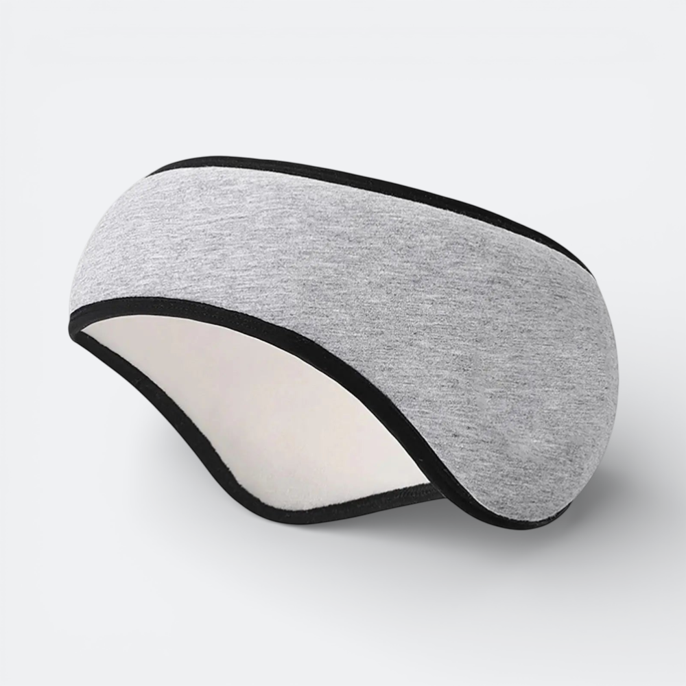AïtaVia grey cotton sleep mask with black trim, designed for blocking noise and light during travel.