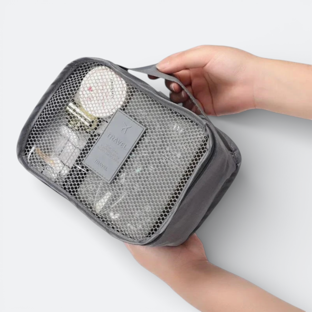 AïtaVia grey mesh travel organizer bag with toiletries inside, featuring a top handle and zipper closure.