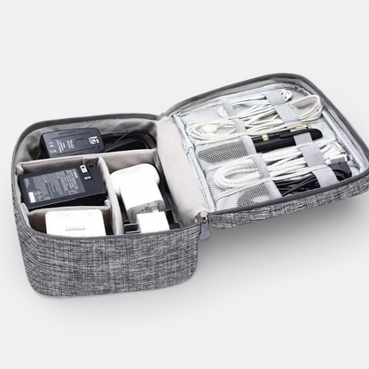 AïtaVia grey fabric travel organizer case with multiple compartments holding chargers, cables, and a pen.