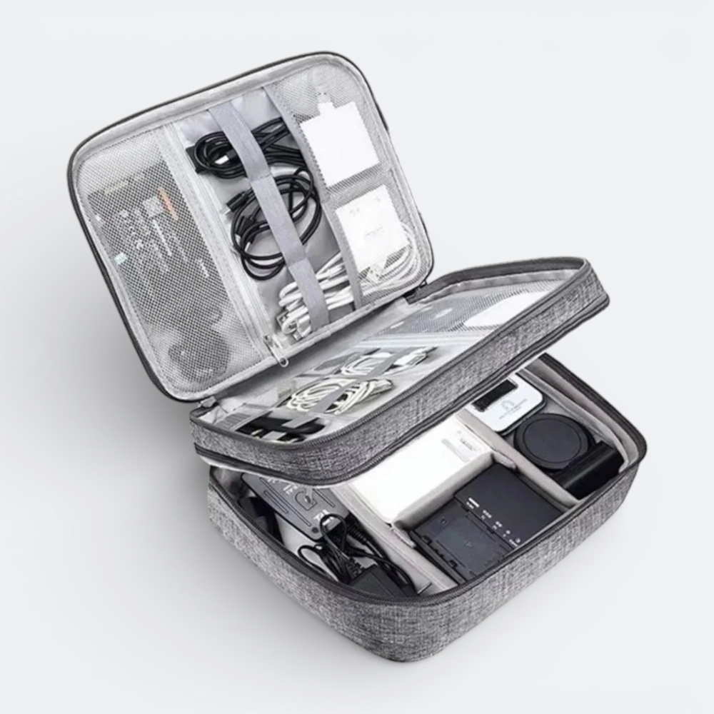 AïtaVia grey fabric travel organizer case with multiple compartments holding cables, chargers, and other electronic accessories.