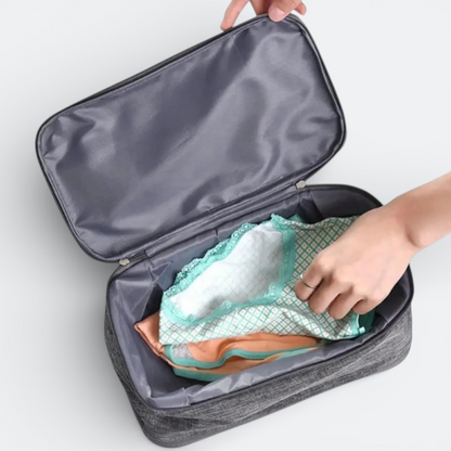 AïtaVia grey travel underwear organizer bag with lace-trimmed items inside.