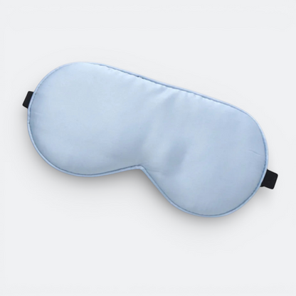 AïtaVia light blue silk sleep mask with black elastic straps for travel comfort and total darkness.