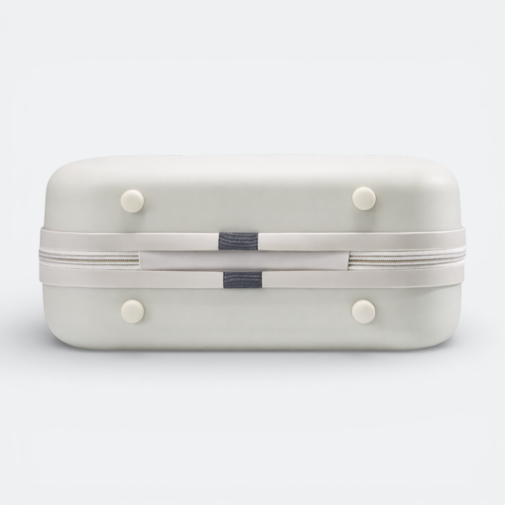 AïtaVia light grey hard-shell cosmetic case with a white zipper and grey fabric accents. Features four white feet.
