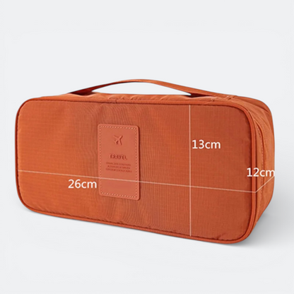 AïtaVia orange travel underwear organizer bag with handle and 'TRAVEL' patch. Dimensions 26x13x12cm.