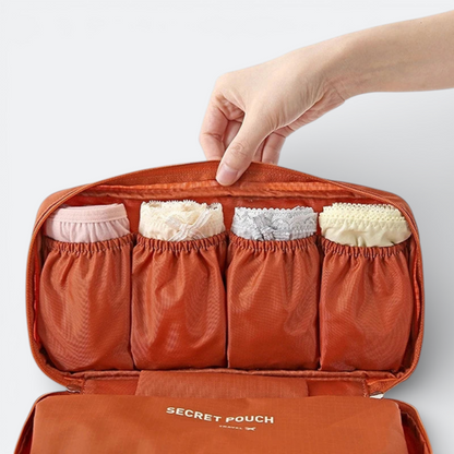 AïtaVia orange travel underwear organizer with four compartments holding folded lingerie.