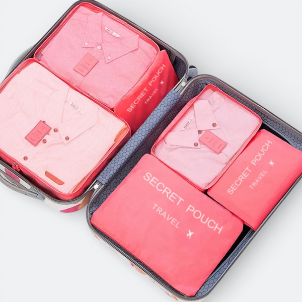 AïtaVia pink mesh packing cubes with shirts neatly folded inside a suitcase.
