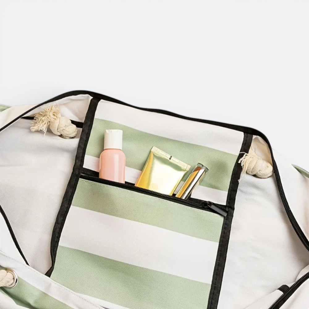 AïtaVia large foldable beach tote bag with green and white stripes, featuring a zippered pocket with toiletries.
