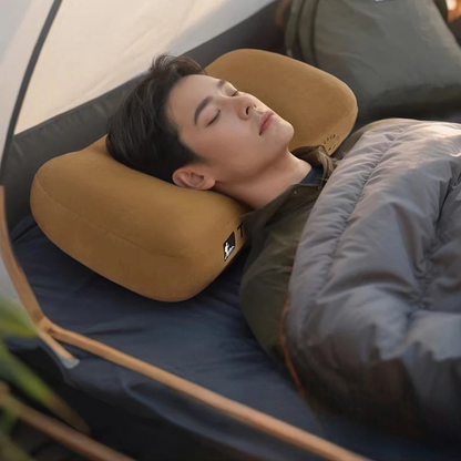 AïtaVia tan inflatable camping pillow supporting a man's head as he sleeps in a tent.