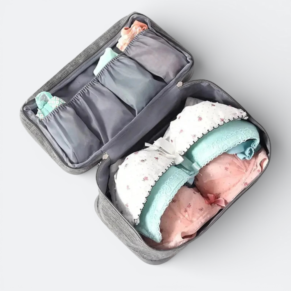 AïtaVia grey travel underwear organizer with multiple compartments for socks and bras. Features padded cups and lace trim.
