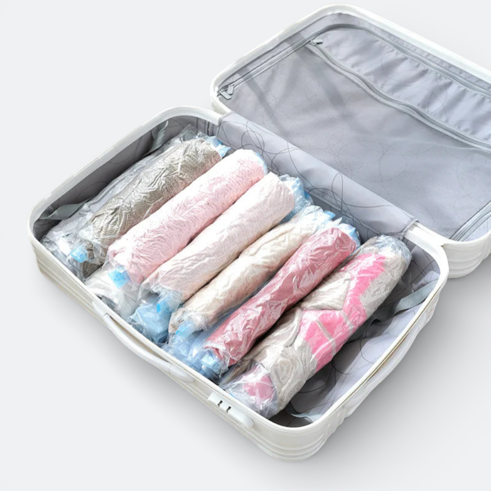 AïtaVia vacuum seal compression bags filled with rolled clothes in various pastel colors inside an open suitcase.