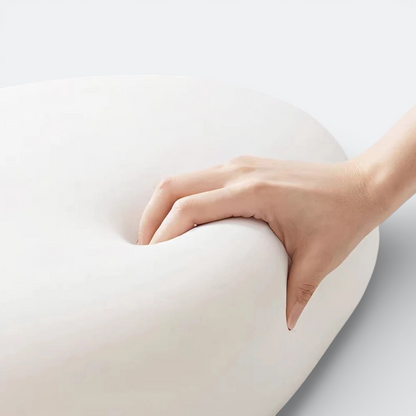 AïtaVia white camping pillow with a hand pressing into its soft, memory foam material.