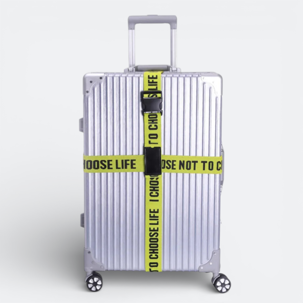 AïtaVia silver suitcase with yellow "TO CHOOSE LIFE" luggage straps and a code lock.